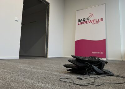 Tastaturen und Kabel liegen auf dem Boden im Hintergrund ein Aufsteller mit dem Logo von Radio Lippewelle Hamm